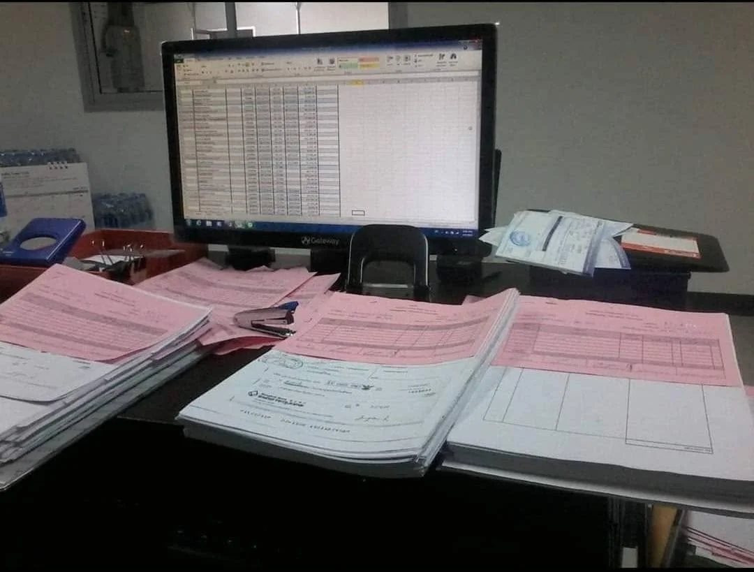 เอกสารใบกำกับภาษีวางบนโต๊ะข้างจอคอมพิวเตอร์